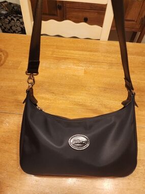 Longchamp black nylon hobo shoulder bag featuring a curved top-zip design